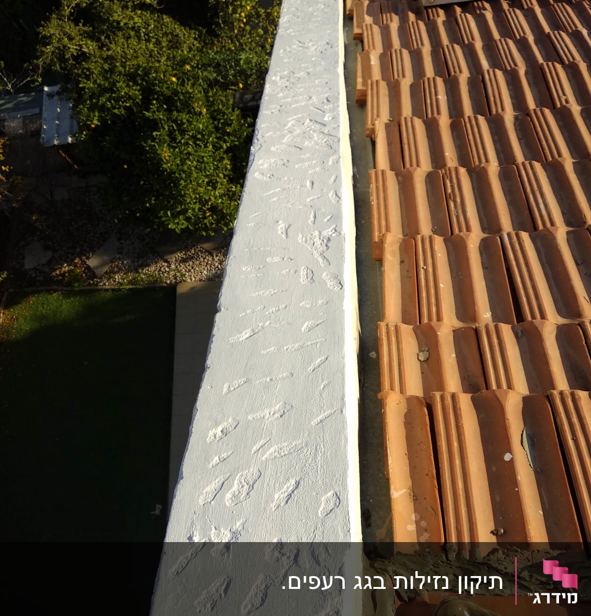 גג רעפים חומים עם קיר בטון צבוע לבן